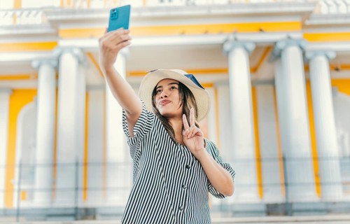 Beautiful tourist girl taking selfie in the cathedral of Granada. Young tourist woman with hat