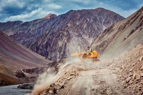 LADAKH, INDIA, SEPTEMBER 10, 2011: Bulldozer cleaning road after landslide in Himalayas. Ladakh,