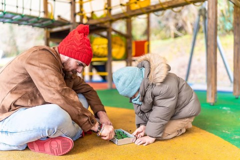 Father and son enjoying a playful moment together, engaging in a table football game at a