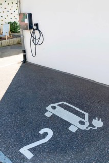 A parking lot with a charging station for electric cars. The parking lot has a white number 2 on