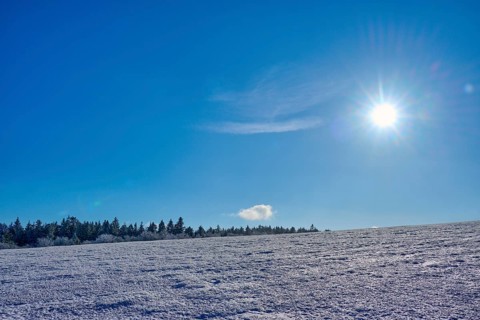 Wide expanse of snow under a clear blue sky with bright sun, winter, Wasserkuppe, Gersfeld, Rhön,