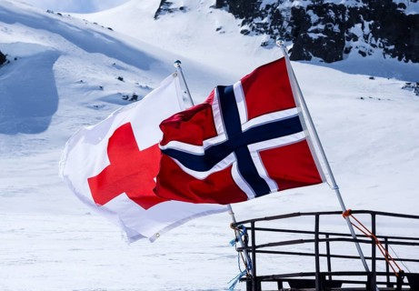 National day 17th May, snowscooter, norwegian flag, near Finse, highest railway station on railway
