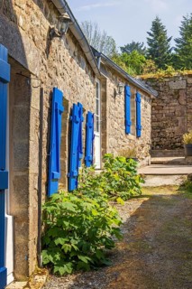 Narrow alley in an old idyllic French villages with picturesque stone houses and blue window