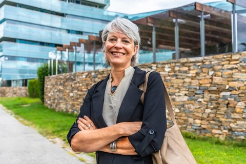 Portrait of a smiling mature businesswoman standing proud with arms crossed outdoors in a financial