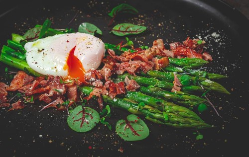 Asparagus with poached egg and fried bacon, micro greens and spices, breakfast, homemade, no people