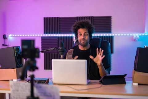Frontal portrait of a influencer recording a video tutorial in a music studio