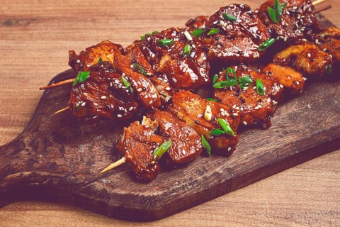 Yakitori chicken kebab, on skewers, with green onions and sesame seeds, top view, without people