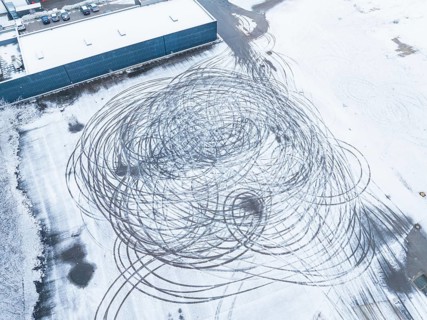 Tyre tracks form large circles on a snow-covered surface as seen from the air, Nagold, Black