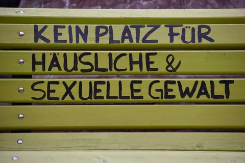Green bench with the inscription No place for domestic and sexual violence, seen in Burghausen,