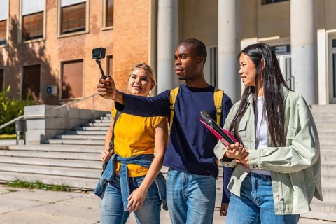 Multi-ethnic university students recording vlog with small portable digital camera