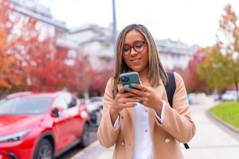 Latin beauty woman using phone sending message online walking in the city