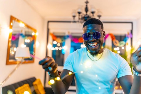 Close-up portrait of a handsome african man laughing dancing in a home night party
