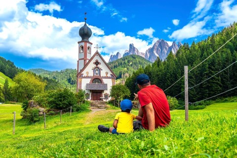 Father and son admiring the stunning view of the idyllic st. Magdalena church in the picturesque