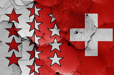 Flags of Valais canton and Switzerland painted on cracked wall