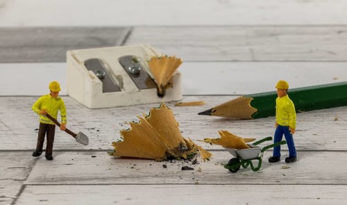 Little figures from little world cleaning up the mess of the mess of the pencil sharpener