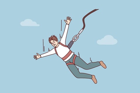 Excited young man jumping with parachute. Smiling guy enjoy extreme sport with rope jumping.