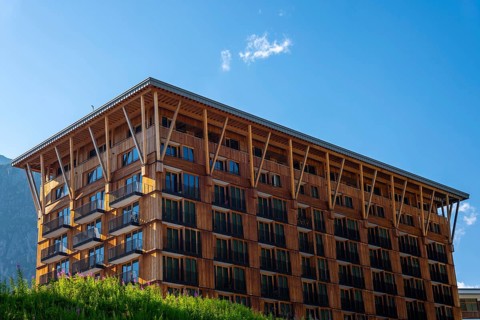 Beautiful Modern Hotel Building in Wood and with Mountain in a Sunny Summer Day in Andermatt, Uri,