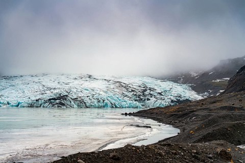 Misty atmosphere enveloping a glacier as it meets the rocky shoreline, iceberg Iceland, glacier,