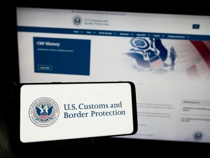 Stuttgart, Germany, 10-29-2023: Person holding smartphone with seal of agency United States Customs