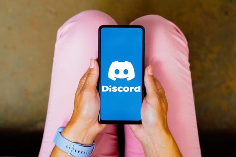 In this photo illustration, the Discord logo is displayed on a smartphone screen