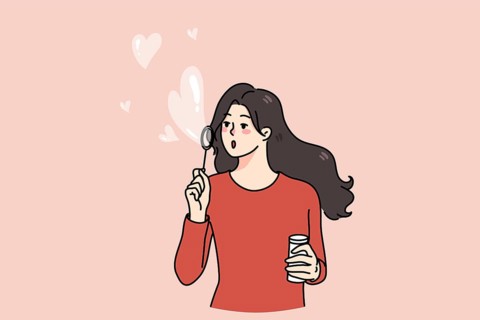 Happy young woman blow soap bubbles with heart shape. Kind girl share spread love and care. Concept