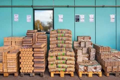 Plastic bags with wood pellets, wood briquettes and firewood at a wholesale market, Allgäu,