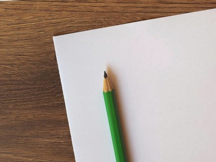 Green pencil on paper sheet desk