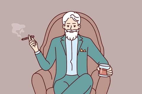 Elderly man aristocrat sits in armchair in expensive formal suit and drinks brandy with cigar.