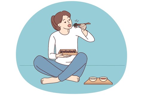 Happy young woman sit on floor eating sushi with chopsticks. Millennial female enjoy traditional