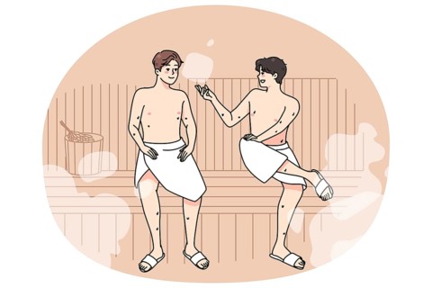 Happy male friends in towels relax in sauna on weekend together. Smiling men enjoy bathhouse