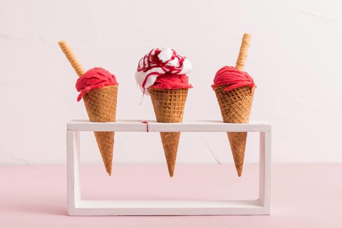 Red ice cream scoop cones with syrup waffle straw stand. High resolution photo