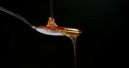 Honey Flowing against Black Background