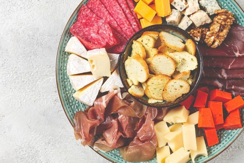Assortment of cheese meat cuts, on a plate, top view, no people