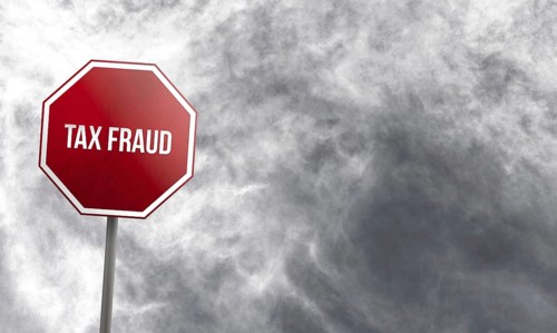 Tax fraud, red sign with clouds in background