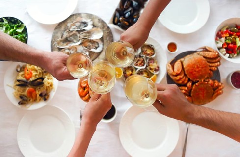 People fine dining seafood and white wine on the table. Top view