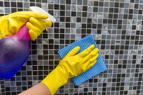 Great home cleaning concept, glove hand wiping tile wall