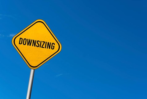 Downsizing, yellow sign with blue sky