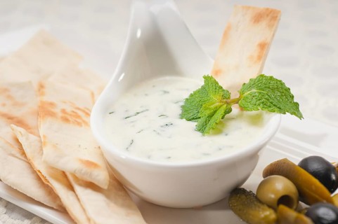 Fresh Greek Tzatziki yogurt dip and pita bread and pickels