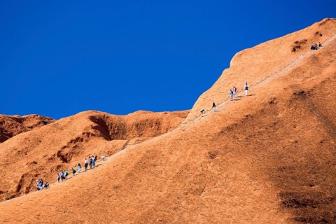 Uluru, Australia, July 4, 2015: Climbers ascend Uluru against the wishes of the Aborginal land