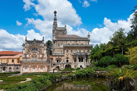Ein prächtiges Schloss mit aufwendiger Architektur und Türmen vor einem blauen Himmel mit Wolken,