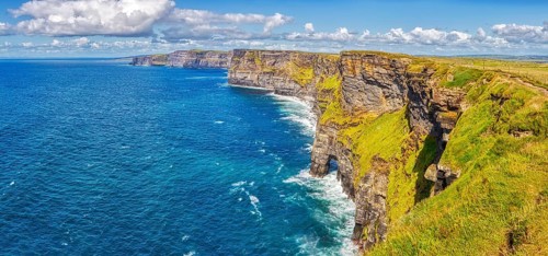 Breathtaking coastal view with green cliffs and deep blue sea under a bright sky, Cliffs of Moher