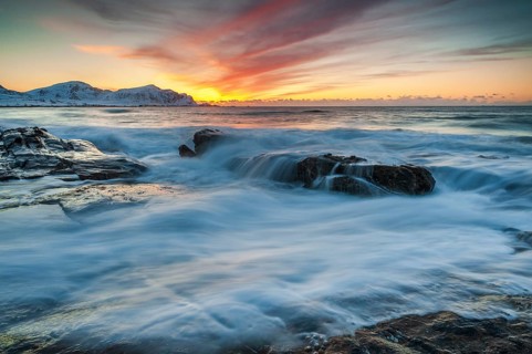 Long exposure, sunset in winter at Skagsanden, rocks washed over by the sea on the beach at