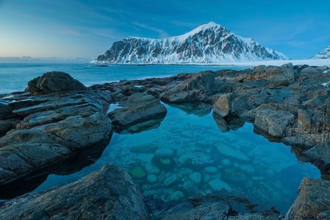 Long exposure, winter at Skagsanden, rocks washed over by the sea on the beach at Flakstad,