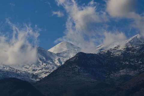 Mountain peaks with snow and clouds under a blue sky, Lefka Ori, White Mountains, mountain massif,