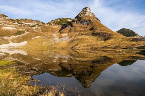 Lake Augstsee and the Atterkogel mountain on the Loser. Autumn, good weather, blue sky. Reflection.