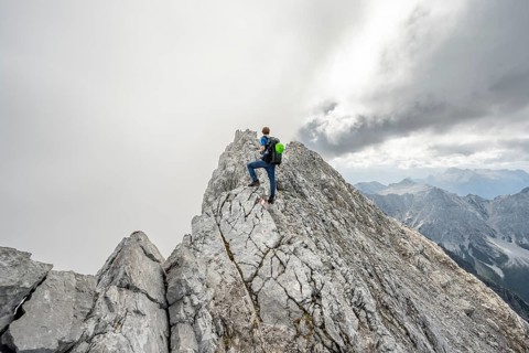 Mountaineer on a narrow rocky ridge, Watzmann crossing to Watzmann Mittelspitze, view of mountain
