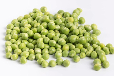 Close-up of a pile of fresh green peas (Pisum sativum) on a white background