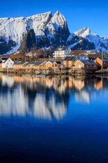 Wooden houses on a fjord off Bergen, morning light, reflection, winter, Reine, Moskenesoya,