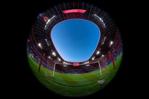Overview, interior, floodlit match, behind-the-goal perspective, goal net, blue hour, fisheye shot,