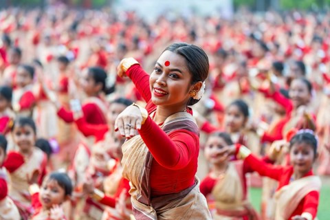 An instructor dance as participants follows the dance step in a Bihu dance workshop ahead of